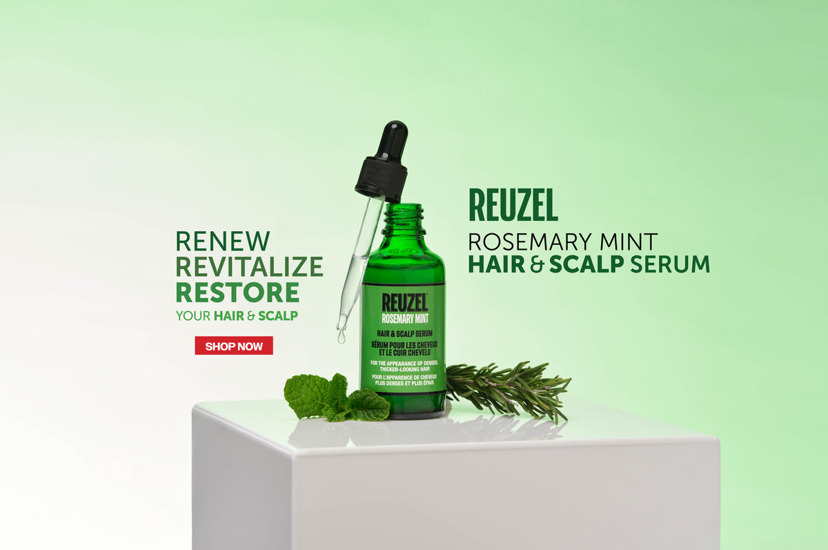 A green glass dropper bottle of Reuzel Rosemary Mint Hair & Scalp Serum displayed on a white pedestal with mint leaves and rosemary sprigs against a light green gradient background.