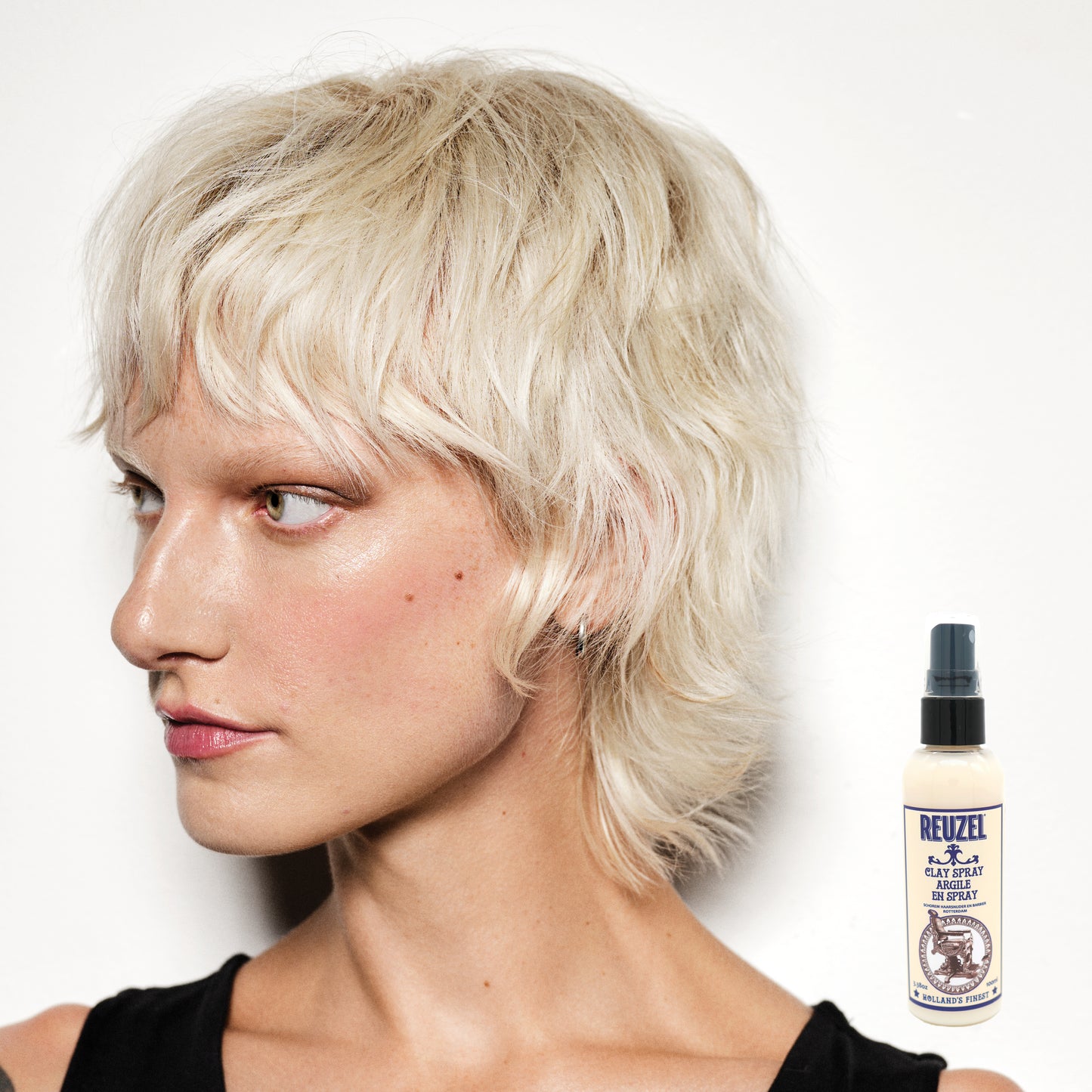 Reuzel Clay Spray hair styling product with a spray bottle, ideal for textured, matte finish hairstyles.