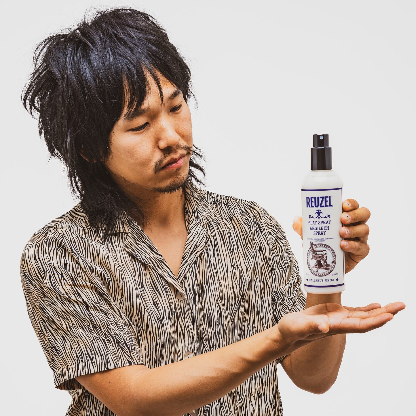 Reuzel Clay Spray hair styling product with a spray nozzle, designed for textured, matte finish styling.