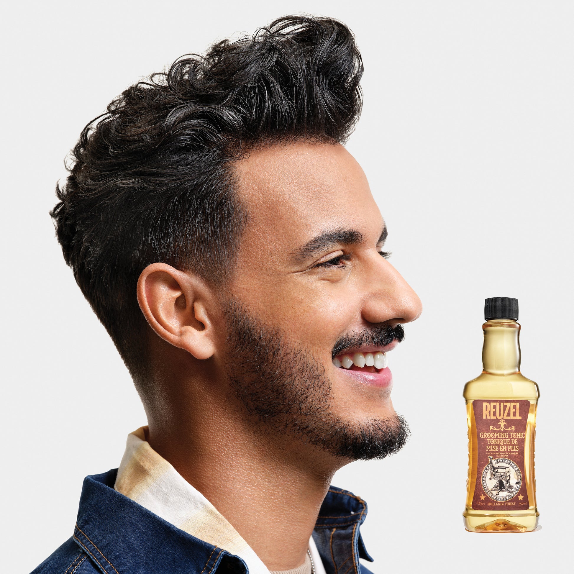 Reuzel Grooming Tonic hair tonic bottle with label, showcasing the product used for styling and scalp care.