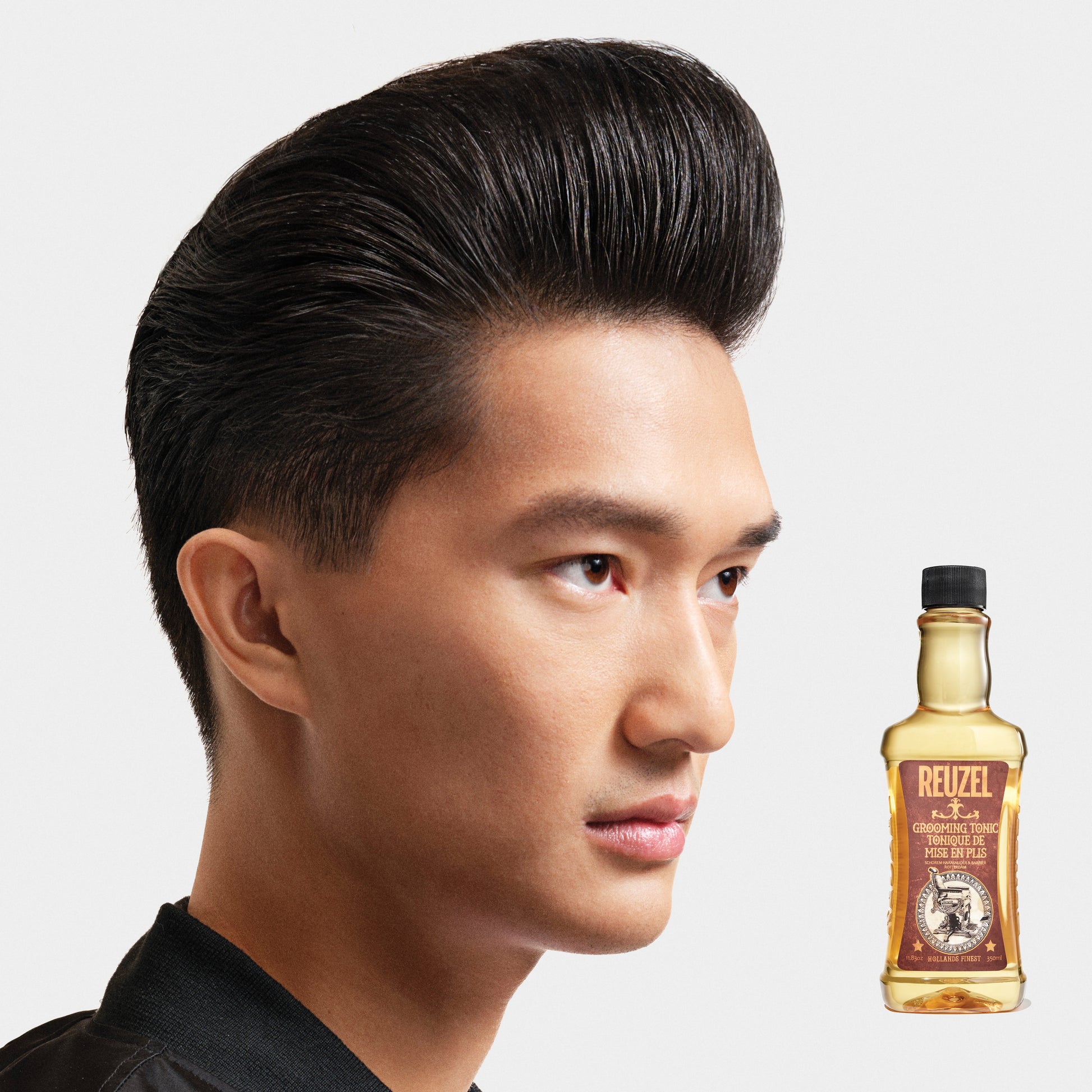 Reuzel Grooming Tonic hair tonic bottle with label, clear liquid inside, designed for styling and hair care.