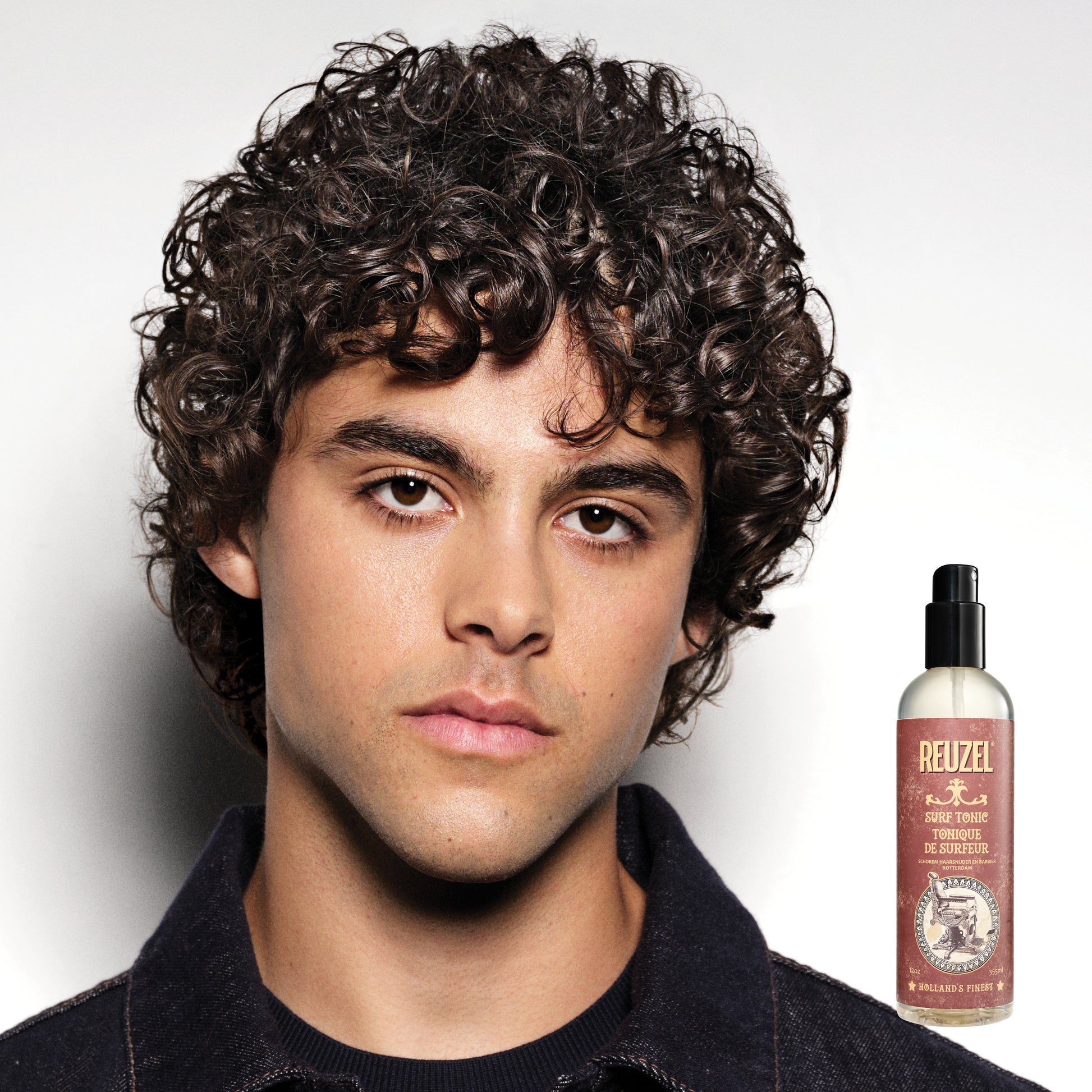 Reuzel Surf Tonic salt spray bottle for textured, beachy hair styling, shown in a close-up image.