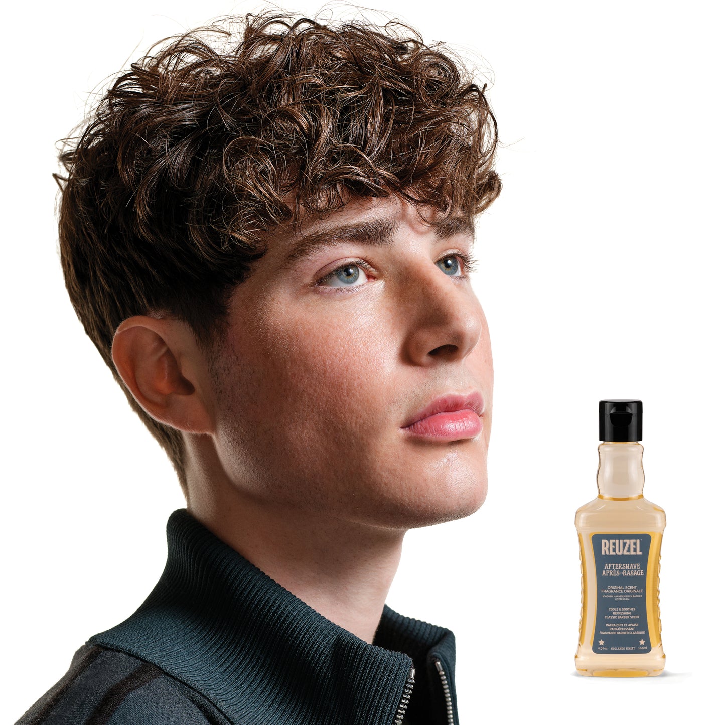 Reuzel Aftershave perfume and cologne bottle with dark label and silver cap, displayed on a neutral background.